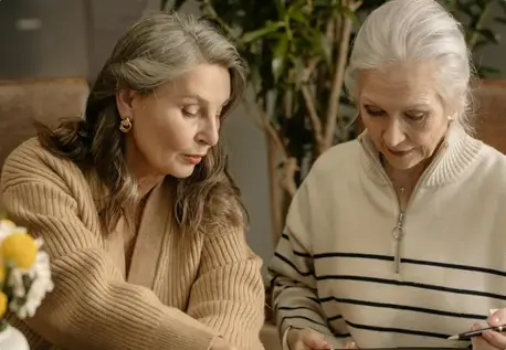 photo of two women looking down reading something