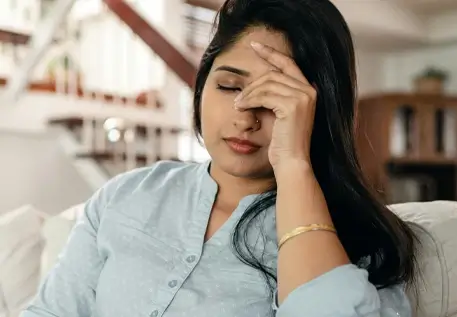 photo of woman with eyes closed and hands on forehead