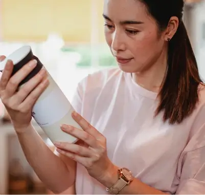 woman looking at bottle in her hands