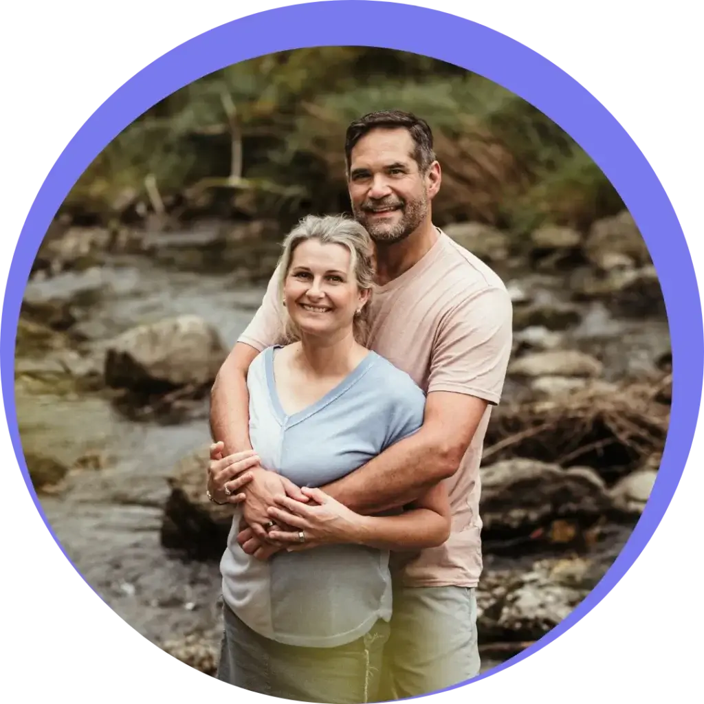 Brian and his wife standing in a loving embrace, smiling at camera