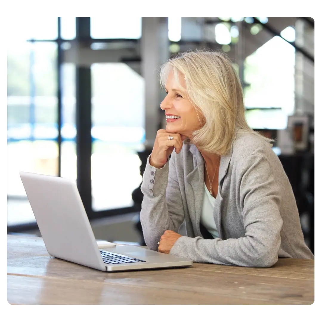 An older woman at her computer smiling