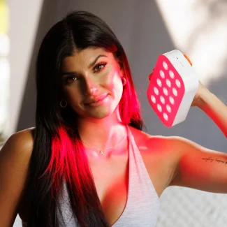 photo of woman looking at camera holding loombox to face