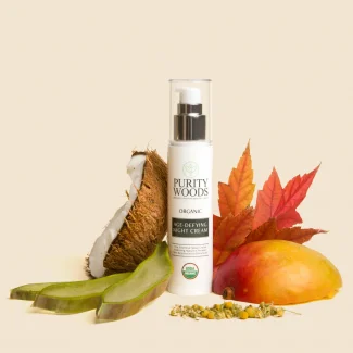 photo of bottle of night cream on table surrounded by leaves, nuts and fruits